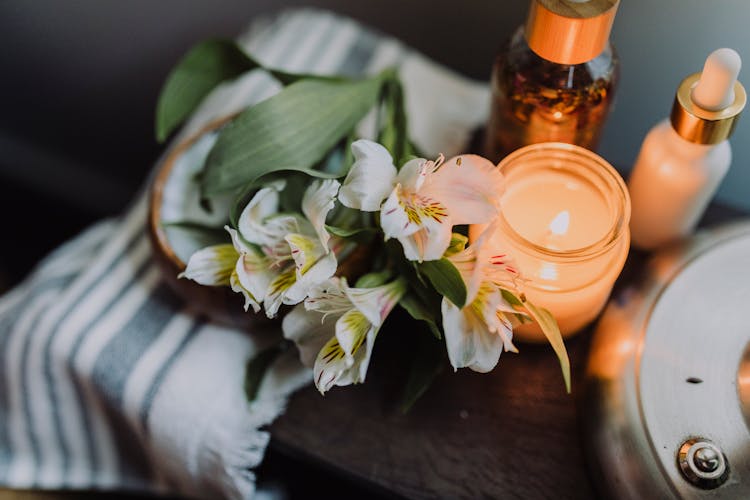 White Flowers Beside A Lighted Candle