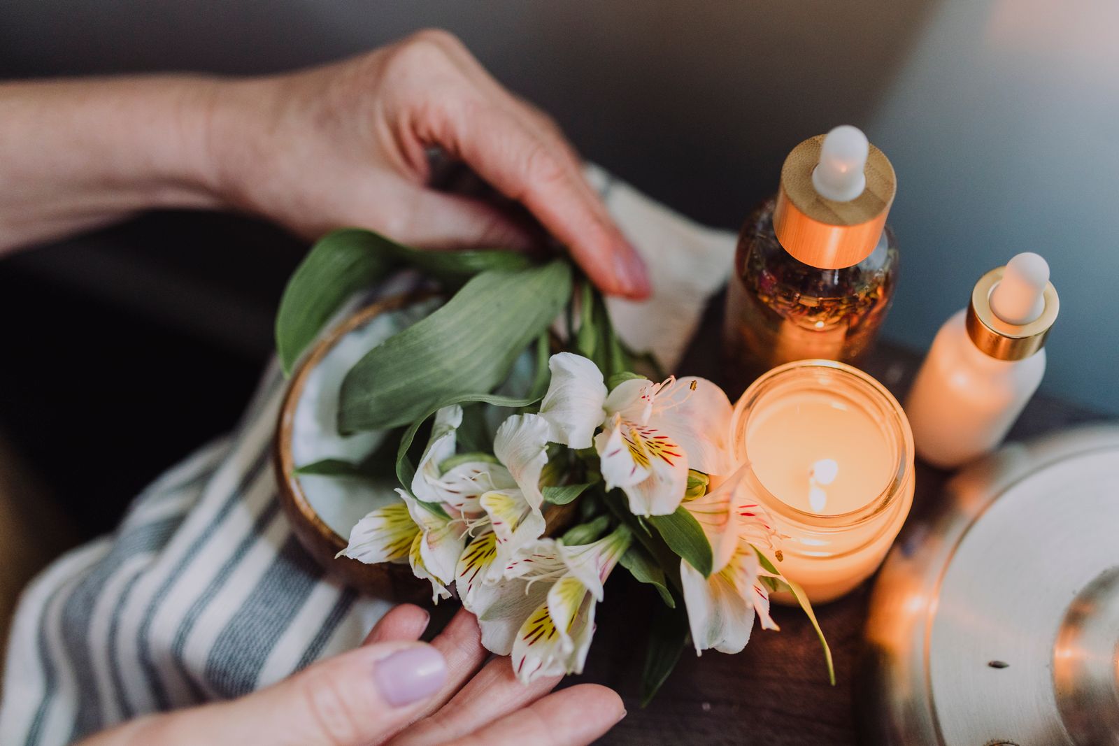 Warm candlelight and white flowers representing a calm spa booking experience