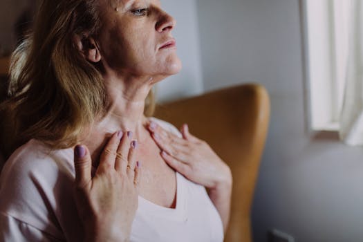 A mature woman gently massaging moisturizer into her neck, highlighting skincare routine and self-care.