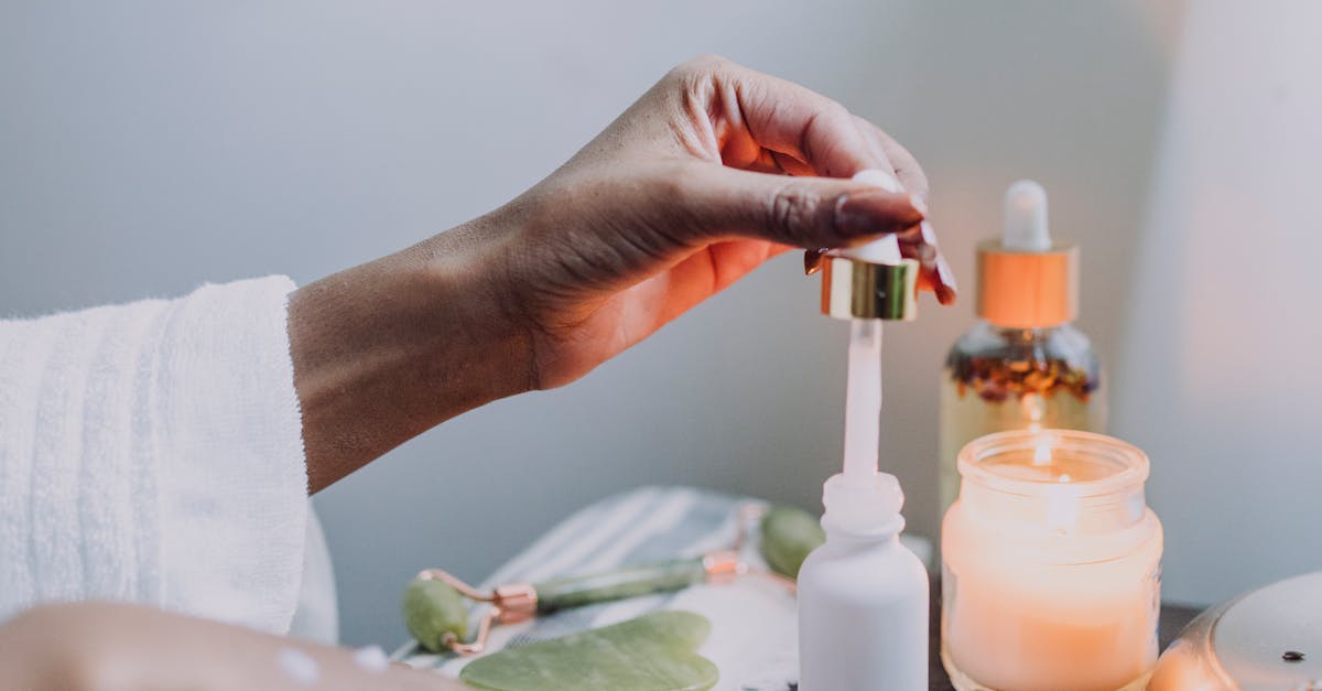 A woman applying moisturizer to her face before going to bed.