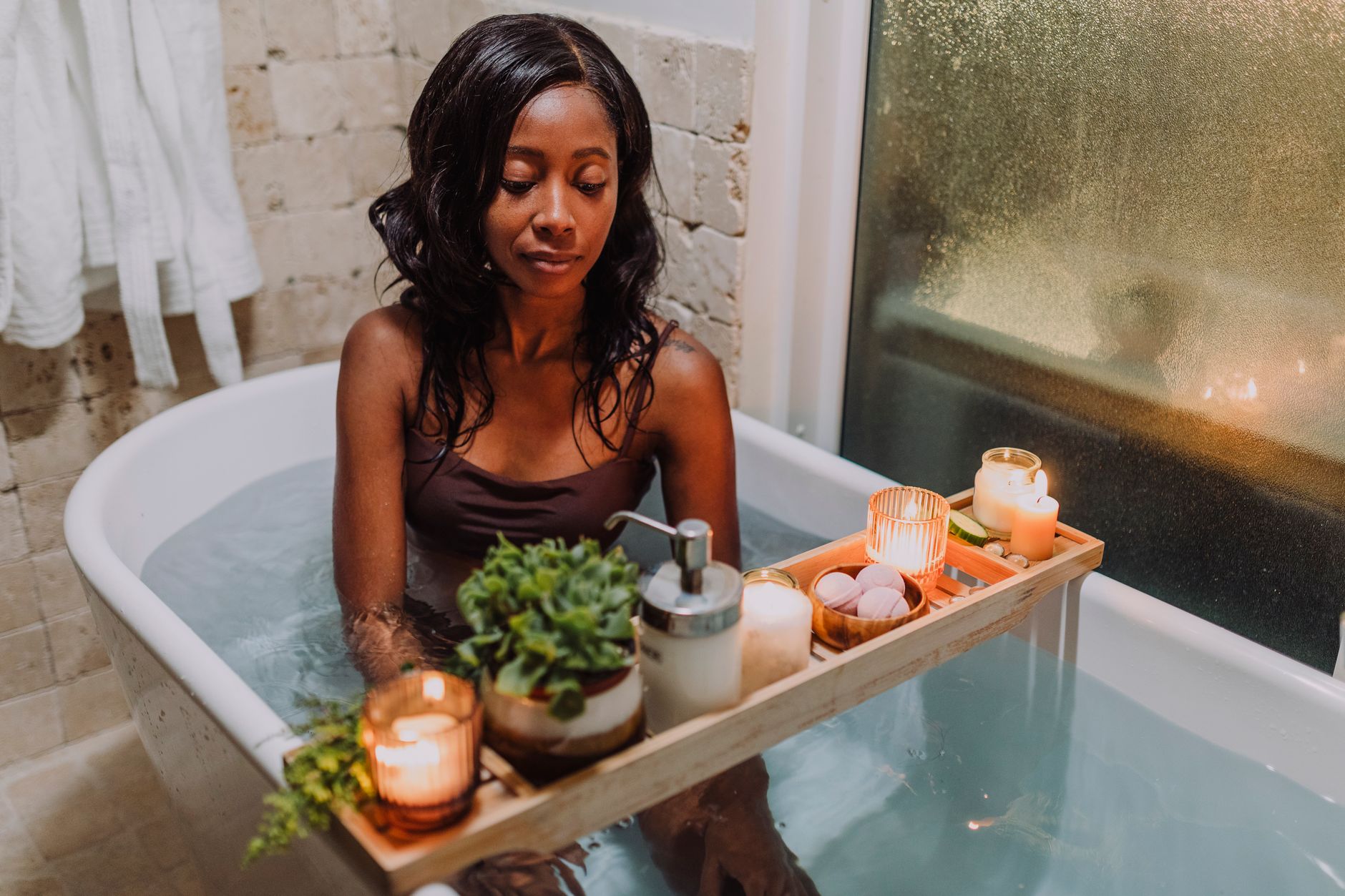 A serene moment of relaxation in the bathtub with candles and a calming atmosphere, perfect for unwinding.