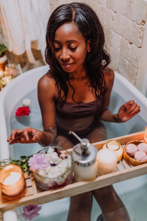 A Woman in Brown Top Sitting in a Bathtub 