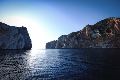 Scenic seascape with rocky mountains in sunlight