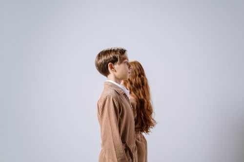 Free Side view of children in coordinated outfits against a white backdrop. Stock Photo
