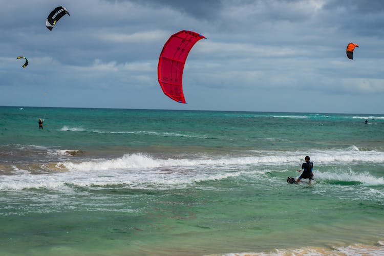 People Paragliding At The Beach