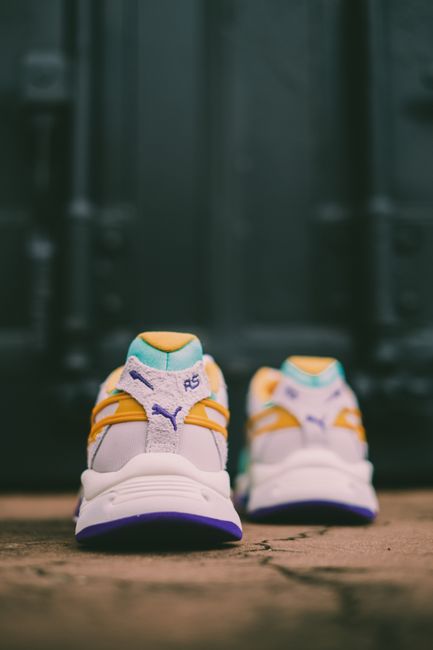 Vibrant sneakers placed on a textured urban surface, perfect for fashion forward themes.