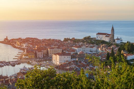 Scenic aerial view of a seaside town with historic architecture at sunset.