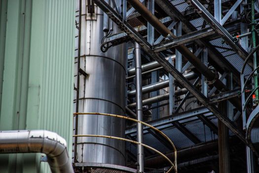 Close-up of an industrial metal structure with pipes and steel framework seen outdoors.