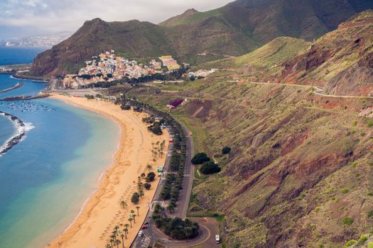 A breathtaking aerial shot of Teresitas Beach and nearby town in Tenerife, showcasing natural beauty.