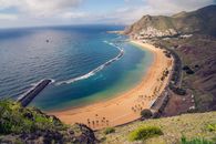 An Asphalt Road Near a Mountain Along a Body of Water