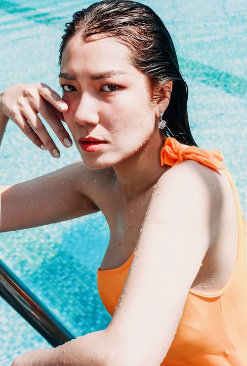 Free A Woman in an Orange Swimsuit in a Swimming Pool Stock Photo