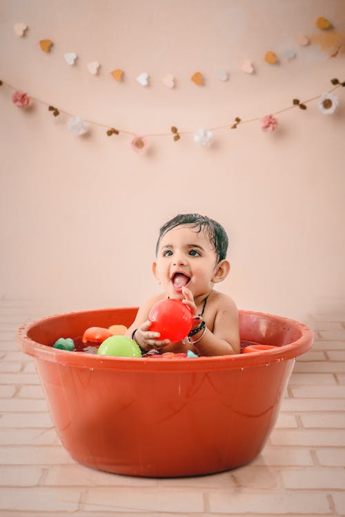 Free A Baby Boy Taking a Bath with Balls Stock Photo