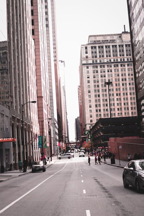 Free Photo of People Crossing Through Street in the Middle of Buildings Stock Photo