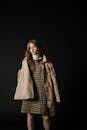 A Girl in Beige Coat Posing at the Studio