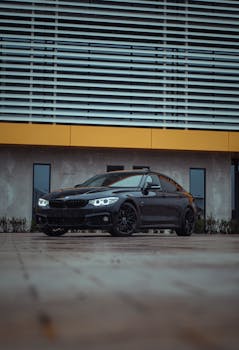 A stylish black BMW parked outdoors in front of a contemporary building, exuding luxury.