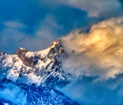 Scenic winter view of snow-covered mountain peaks in Wyoming, USA, with a dramatic sky.