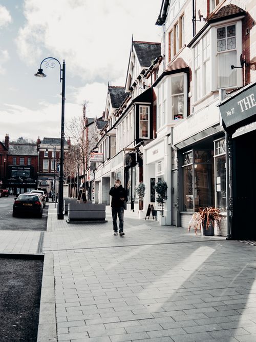 Free A serene view of Colwyn Bay's urban street with charming architecture and a strolling pedestrian. Stock Photo