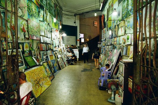 Vibrant art exhibition corridor in Ho Chi Minh City, featuring diverse paintings and visitors.
