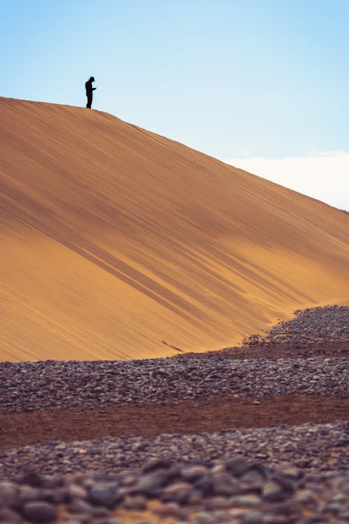 A Person Standing on Brown Sand