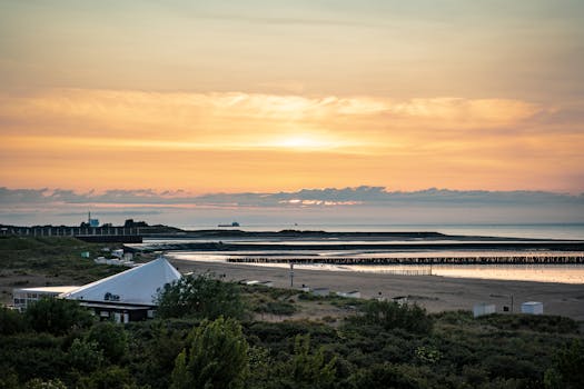 Beautiful sunrise over a serene beach landscape with vibrant colors and tranquil sea view.