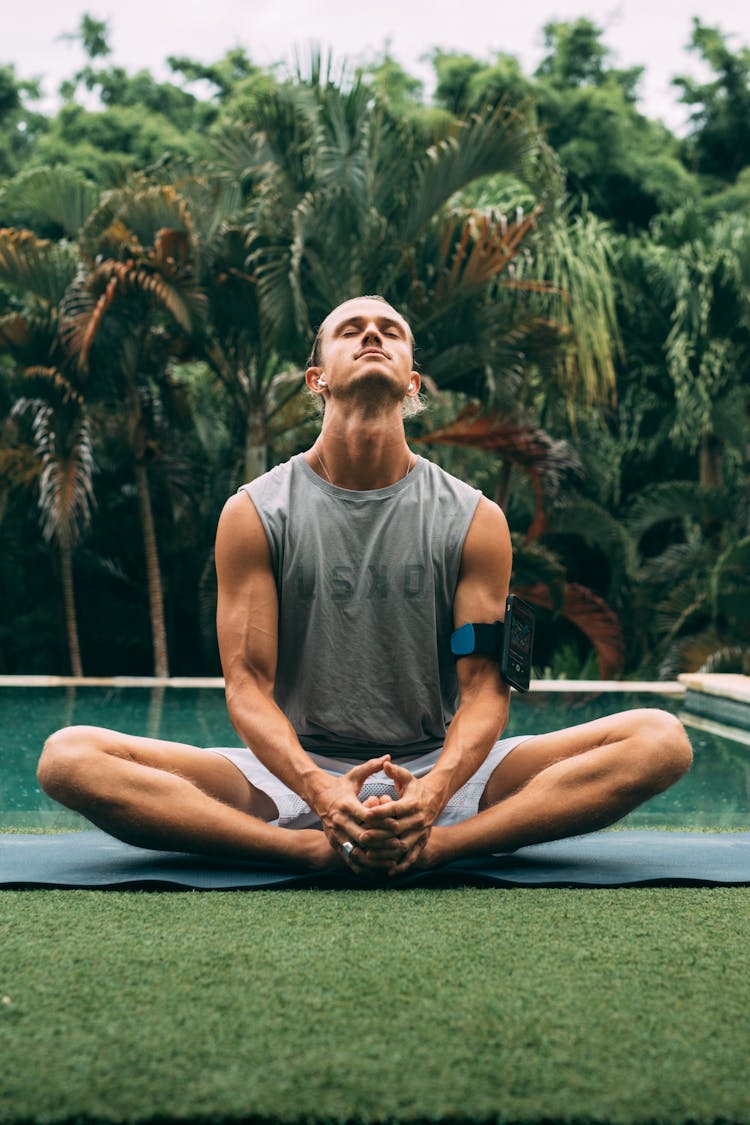 Man Sitting By The Poolside In Yoga Pose