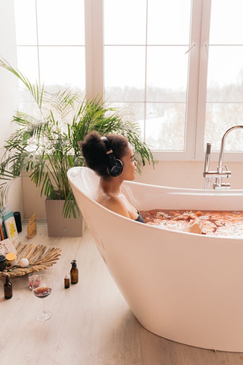 Free A Woman in Bathtub with Headphones Stock Photo