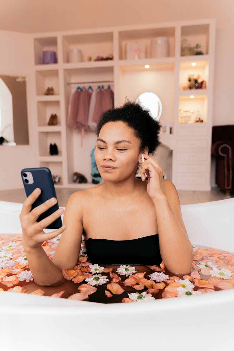 Woman Using A Phone In A Flower Bath