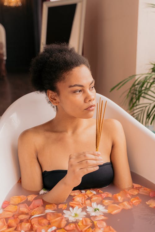 Woman Sitting in a Bath with Floating Flowers 