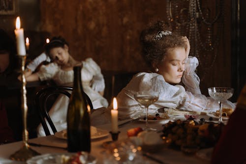 Woman in Historic Dress Sleeping on Table after Party