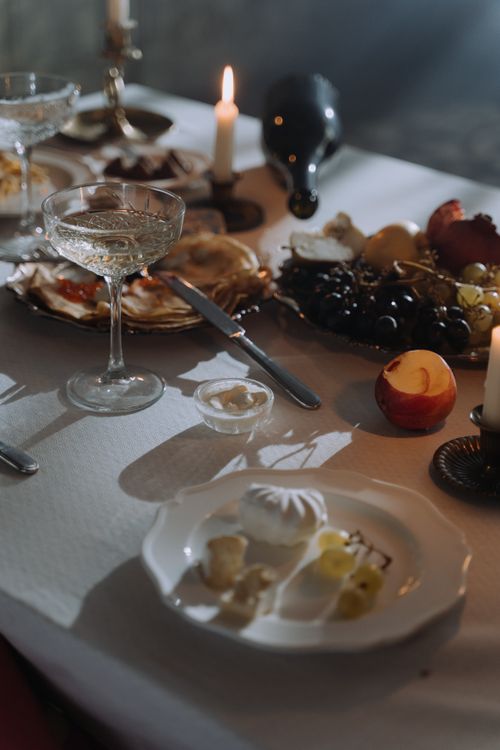 Free Charming dinner setting with fruits, cheese, and candles on a table, evoking a cozy evening ambiance. Stock Photo
