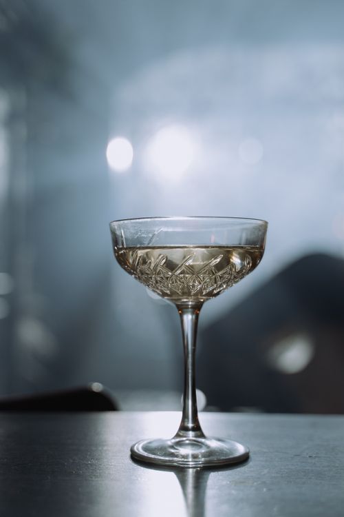 Free Crystal champagne glass with bubbles. Stylish and elegant drink setting in soft lighting. Stock Photo