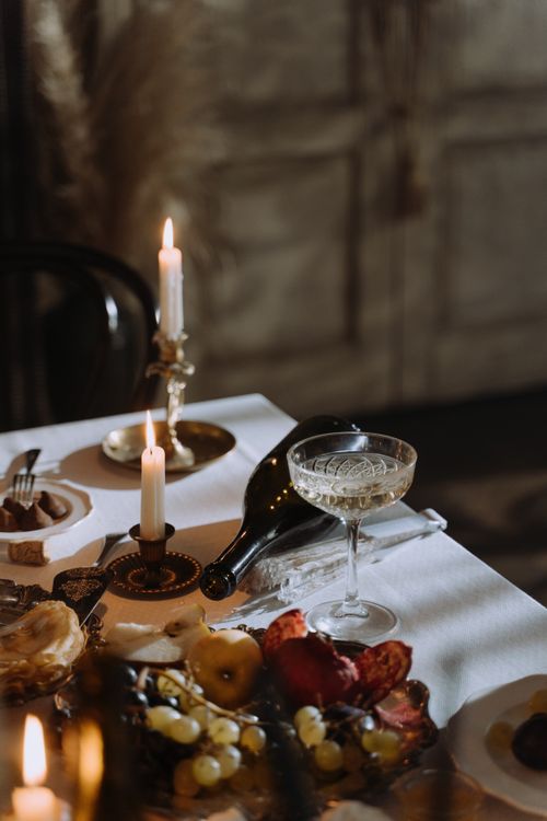 Free A sophisticated dining table with candles, wine, and gourmet food for a cozy evening. Stock Photo