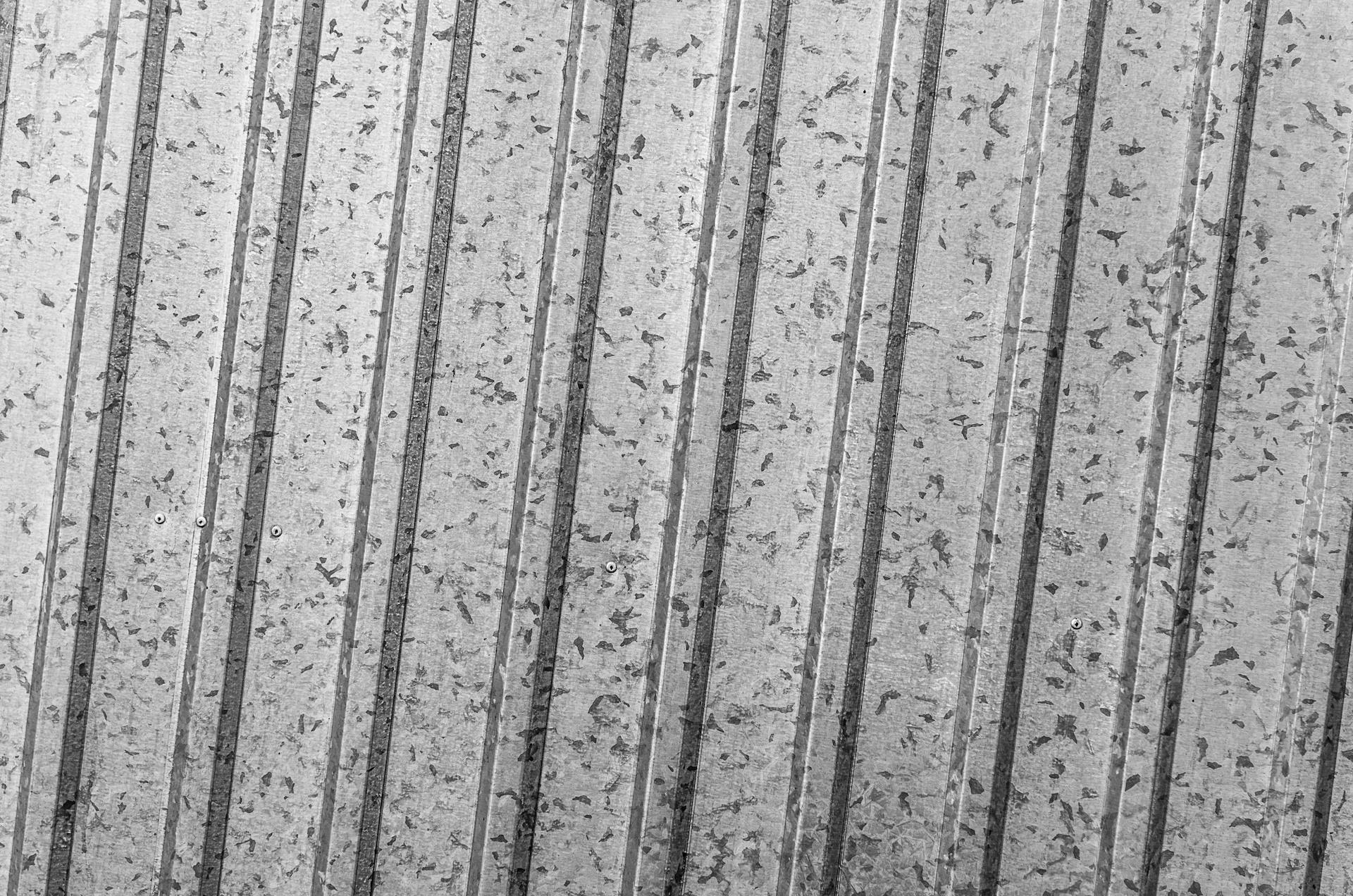 A close-up view of a corrugated metal sheet with a striped pattern and textured surface.