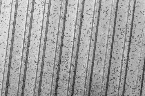Free A close-up view of a corrugated metal sheet with a striped pattern and textured surface. Stock Photo