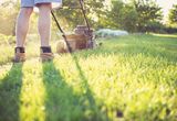 Person mowing a green lawn