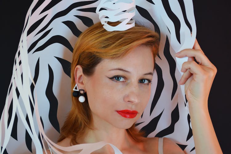 Model In Modern Earrings With Paper Crown On Black Background