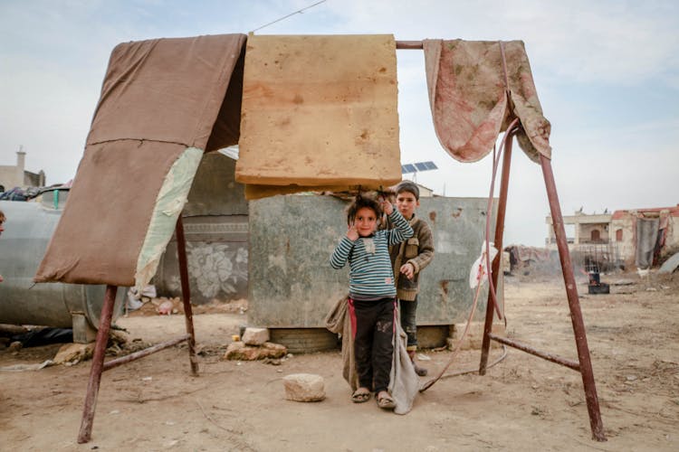 Children Playing Among Old Shabby Mattresses