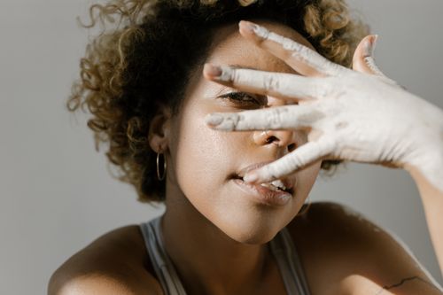 Free Artistic portrait of a woman with painted hand, showcasing creativity and self-expression. Stock Photo