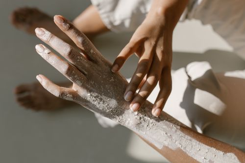 Free Close-up of two hands engaged in a clay treatment, capturing texture and artistic touch. Stock Photo