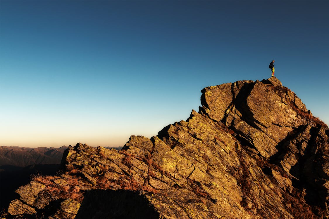 Free Man Standing on Top of Rock at Daytime Stock Photo