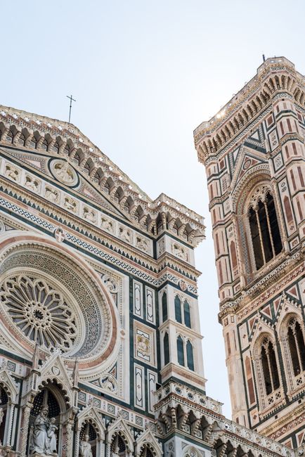Close-up of Florence Cathedral's ornate facade and bell tower showcasing intricate design and sculptures.
