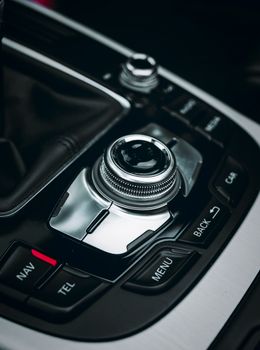 Close-up of a luxury car control panel with sleek buttons and metallic finish.