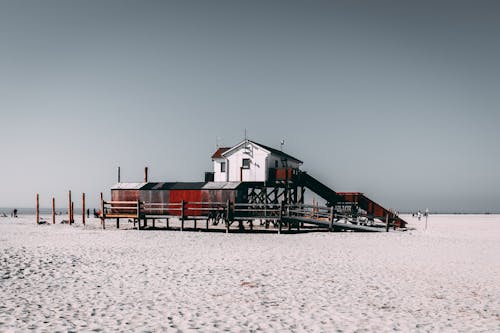 Free Red and White Wooden House on White Sand Stock Photo
