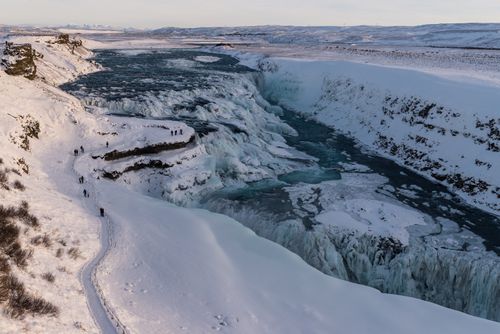 Free A breathtaking winter view of the icy Gullfoss Waterfall in Iceland, surrounded by snow-covered landscapes. Stock Photo