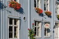 Picturesque library facade with vibrant red flowers in window boxes on a sunny day.