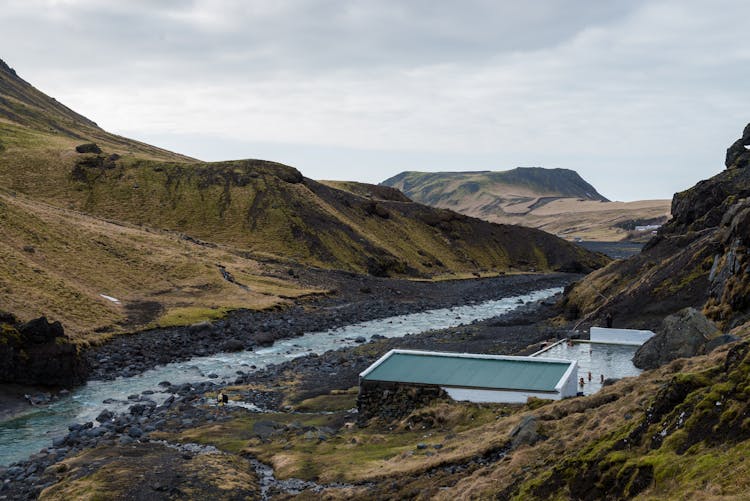 Geothermal Pool By River Among Hills