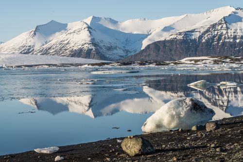 Free Snow-covered mountains reflecting in a tranquil, icy lake, creating a picturesque winter landscape. Stock Photo