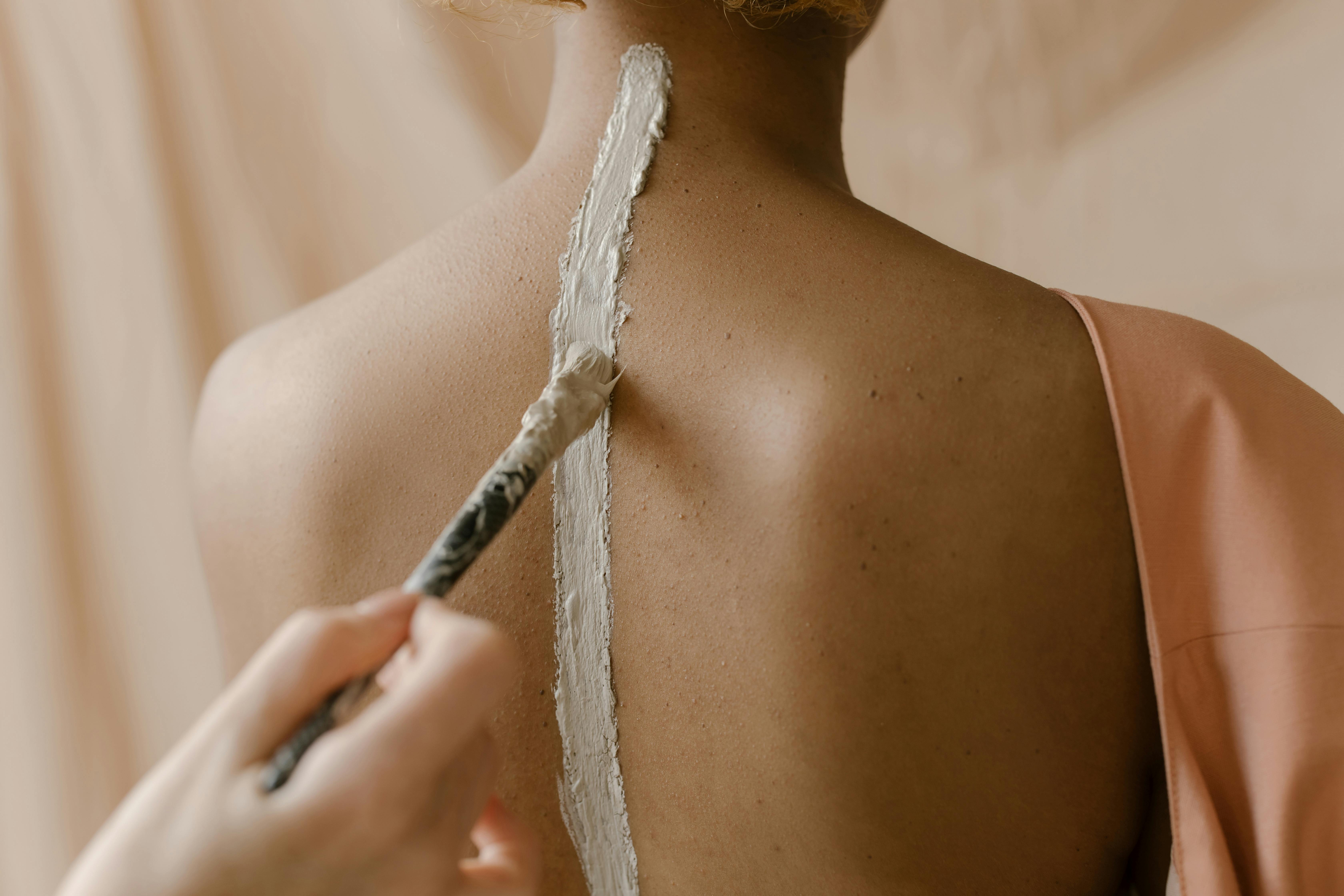 a person applying white paint on a skin