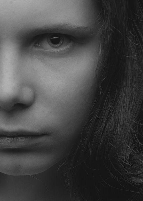 Free Dramatic black-and-white close-up of a woman's face focusing on the eye and expression. Stock Photo