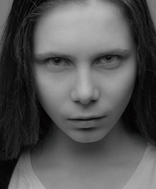 Free Intense monochrome close-up portrait of a young woman with a neutral expression. Stock Photo